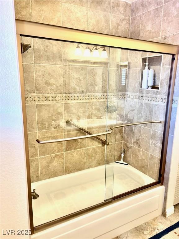 bathroom featuring shower / bath combination with glass door