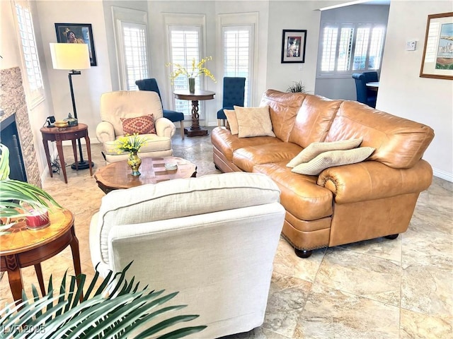 living room with a fireplace and baseboards