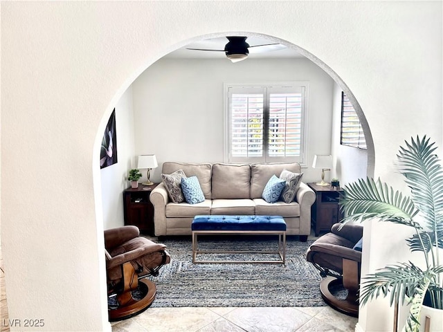 living room with arched walkways and a textured wall