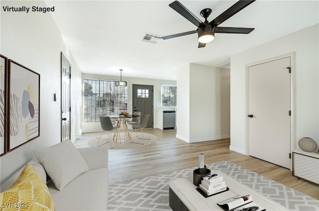 living room featuring ceiling fan and light hardwood / wood-style floors