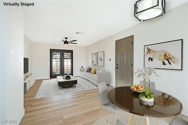 living room featuring french doors, ceiling fan, and light hardwood / wood-style floors