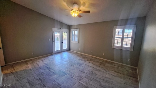 empty room with french doors, ceiling fan, vaulted ceiling, and hardwood / wood-style flooring