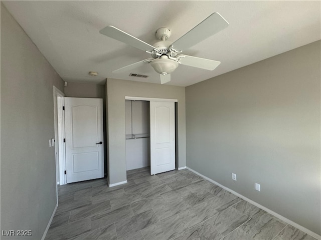 unfurnished bedroom with ceiling fan and a closet