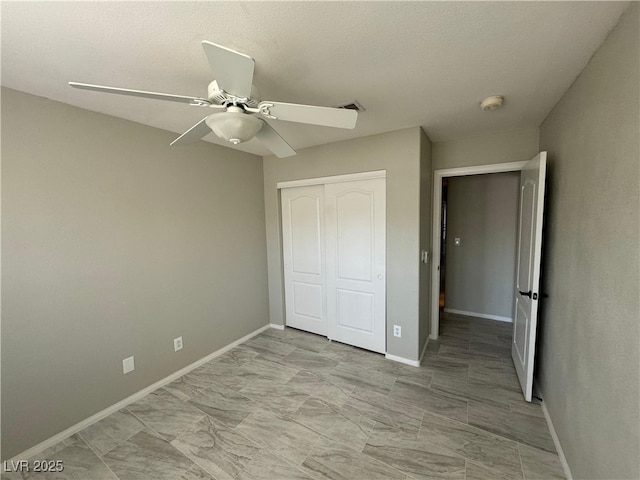 unfurnished bedroom with ceiling fan and a closet