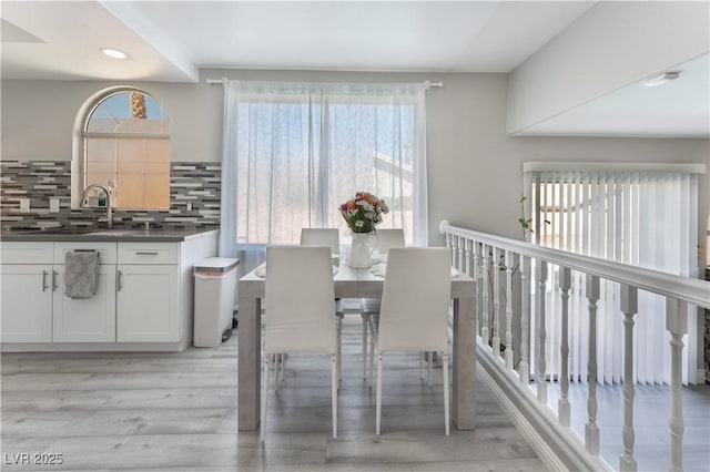 dining room featuring sink and light hardwood / wood-style flooring