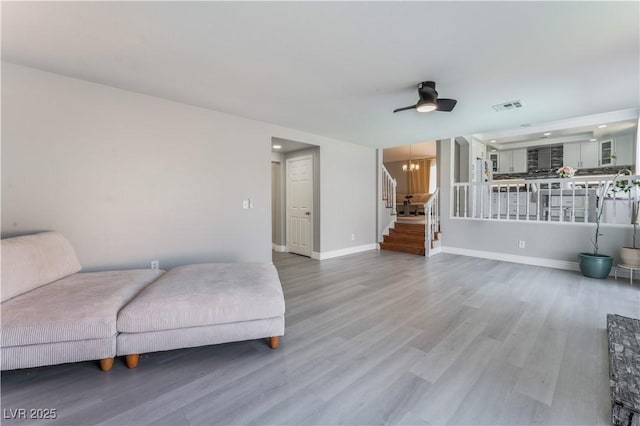 living area with hardwood / wood-style flooring and ceiling fan with notable chandelier