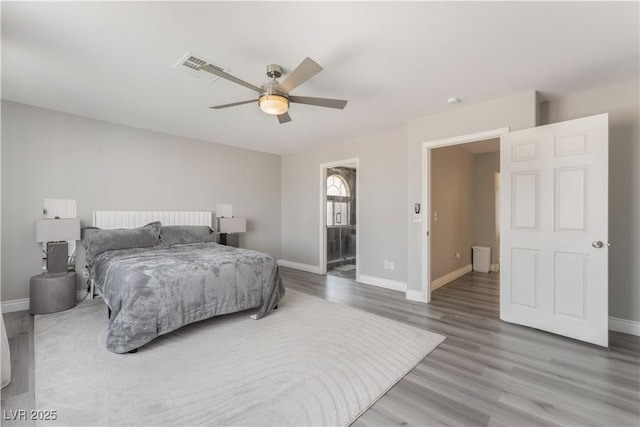 bedroom featuring hardwood / wood-style flooring, ceiling fan, and ensuite bath