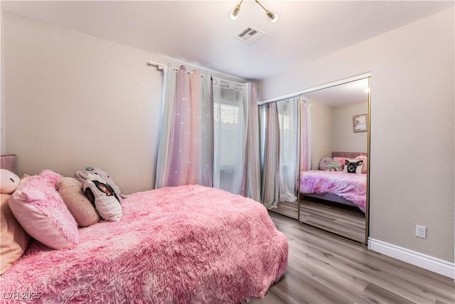 bedroom with wood-type flooring and a closet