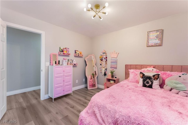 bedroom with a chandelier and light wood-type flooring