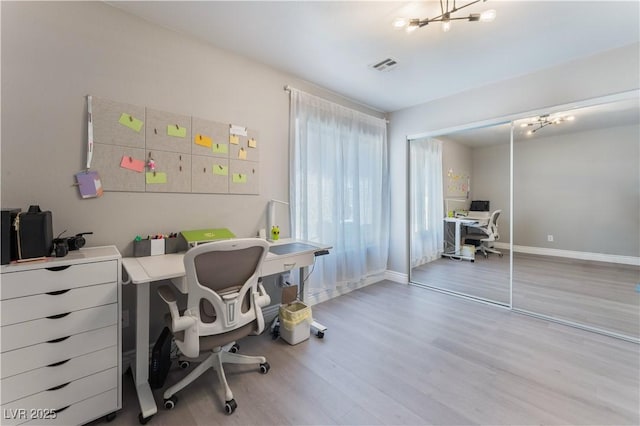 office space featuring hardwood / wood-style flooring and an inviting chandelier