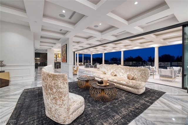 living room featuring beamed ceiling, coffered ceiling, recessed lighting, a decorative wall, and ornate columns