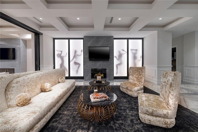 living room featuring coffered ceiling, beam ceiling, a fireplace, a decorative wall, and marble finish floor