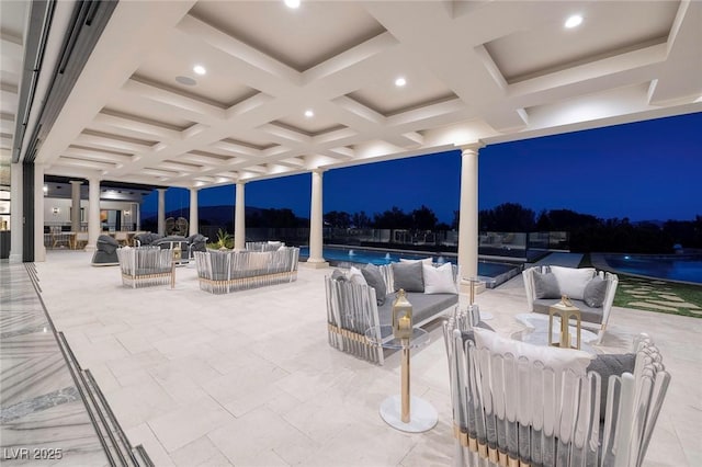 patio at night featuring an outdoor living space and an outdoor pool