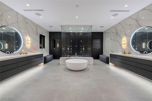 full bathroom featuring a shower stall, tile walls, a soaking tub, stone wall, and a sink