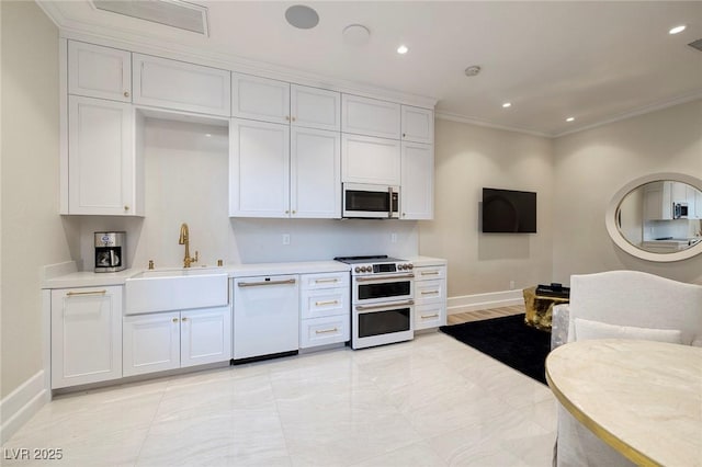 kitchen with white appliances, baseboards, a sink, light countertops, and crown molding