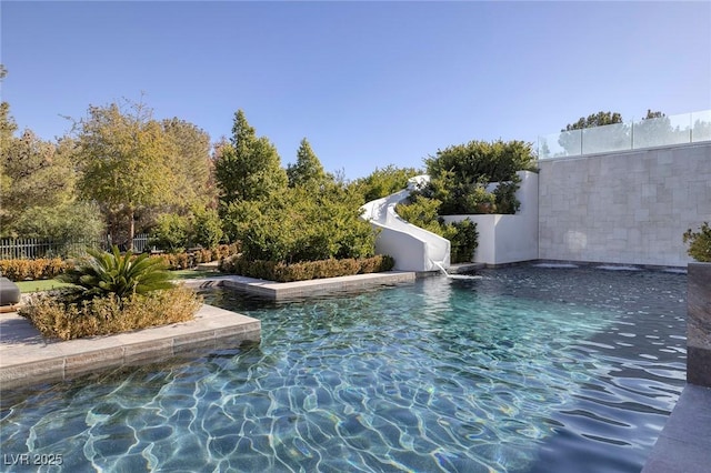 view of pool with a fenced in pool, a water slide, and fence