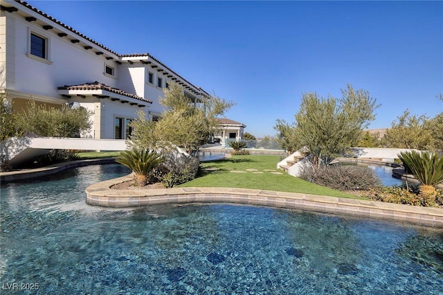 outdoor pool featuring a lawn