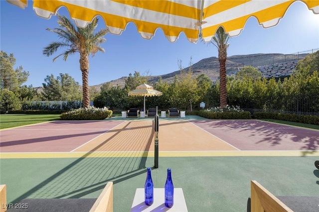 view of tennis court featuring community basketball court and a mountain view