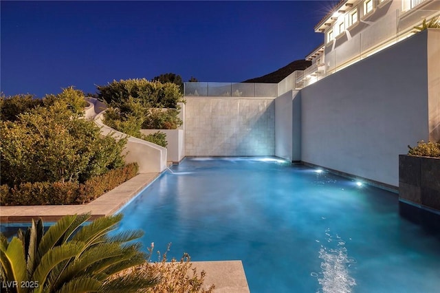 view of pool at twilight