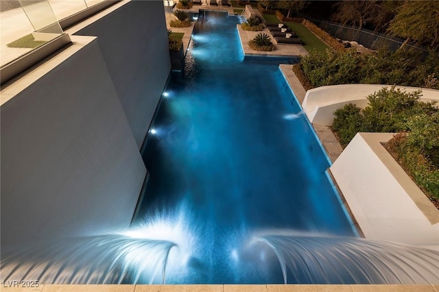 view of swimming pool featuring a fenced in pool, a water slide, and fence