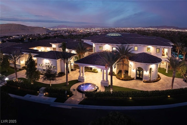 mediterranean / spanish-style home featuring french doors, a patio, and a tile roof