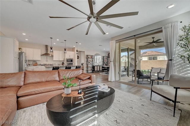 living room with ceiling fan and light hardwood / wood-style flooring