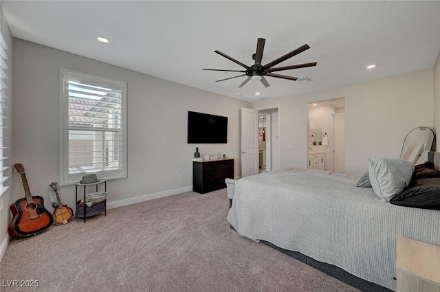 bedroom with ceiling fan, light colored carpet, and ensuite bath