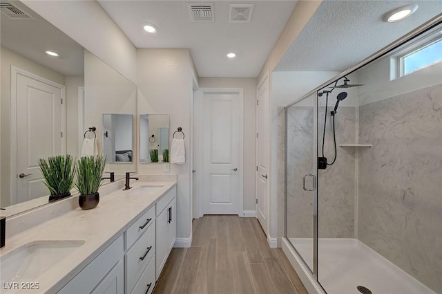 bathroom featuring vanity, hardwood / wood-style floors, and a shower with shower door