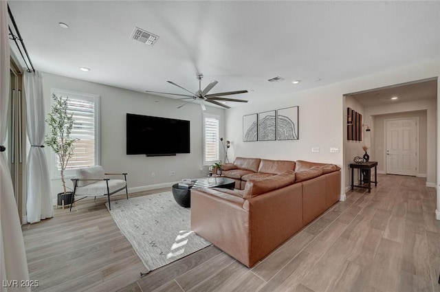 living room featuring ceiling fan and light hardwood / wood-style flooring