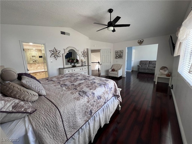 bedroom featuring dark wood-type flooring, ceiling fan, connected bathroom, a textured ceiling, and vaulted ceiling