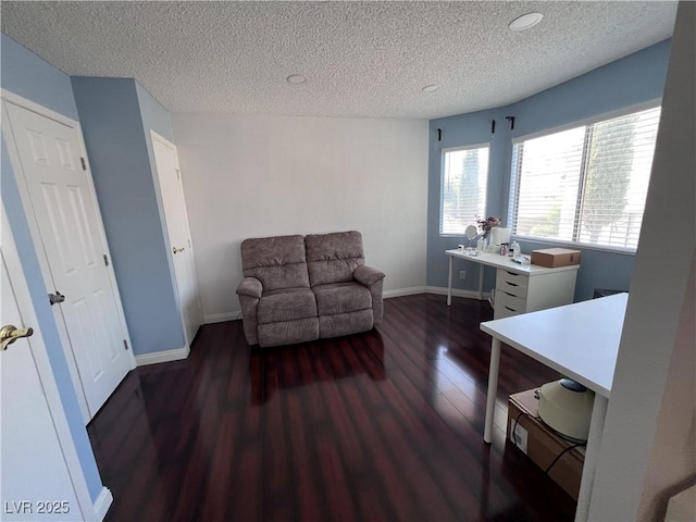 living area with a textured ceiling and dark hardwood / wood-style flooring