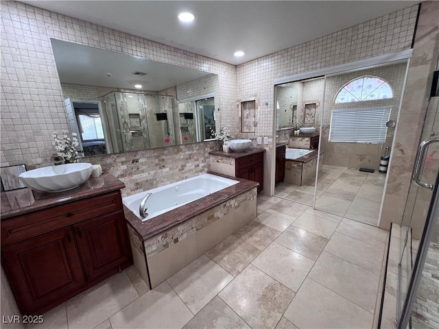 bathroom with tile walls, vanity, tile patterned flooring, and shower with separate bathtub