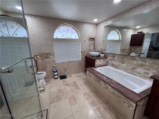 full bathroom with independent shower and bath, tile walls, tile patterned flooring, vanity, and toilet