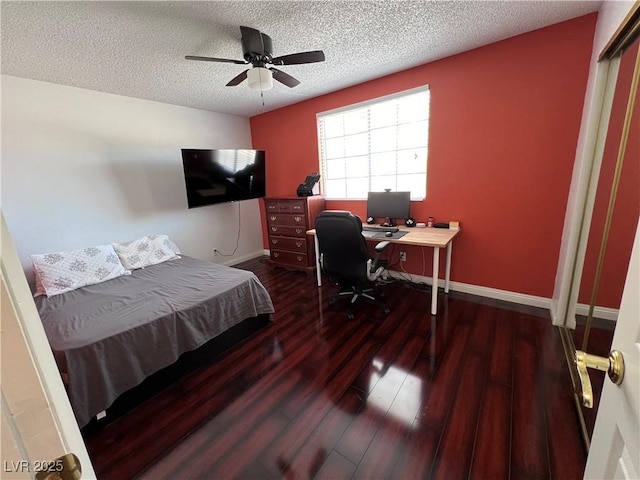 bedroom with dark wood-type flooring, ceiling fan, and a textured ceiling