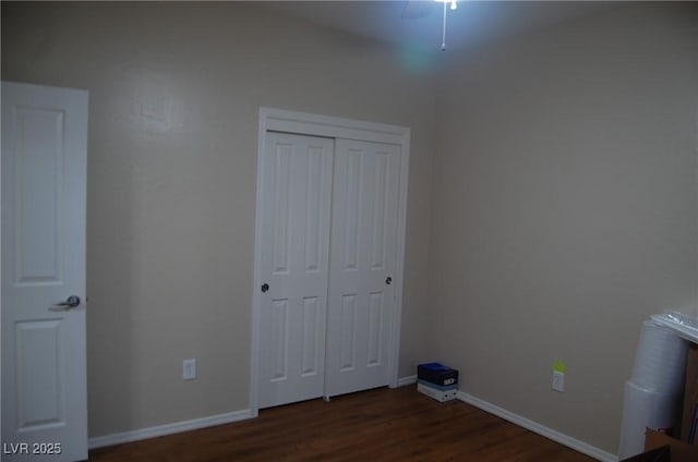 unfurnished bedroom with dark hardwood / wood-style floors and a closet