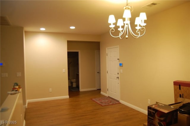 foyer entrance featuring wood-type flooring and a chandelier