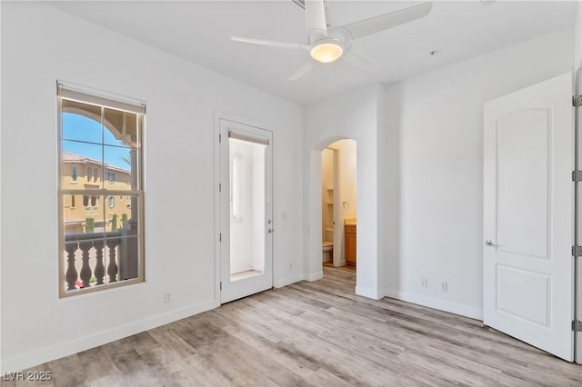 unfurnished bedroom featuring ensuite bath, light hardwood / wood-style floors, and ceiling fan