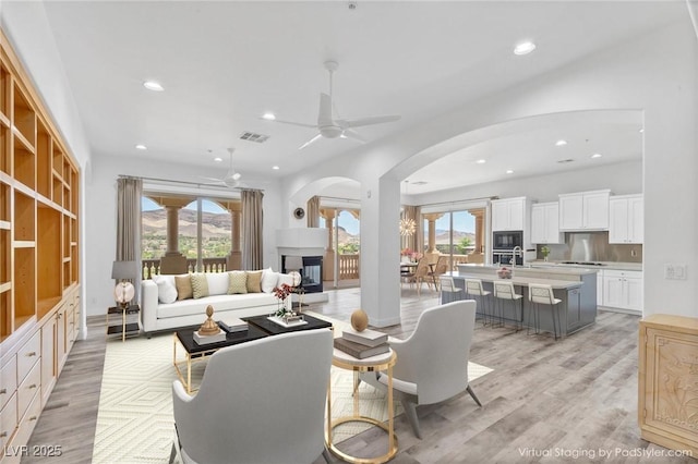 living room featuring ceiling fan and light hardwood / wood-style flooring