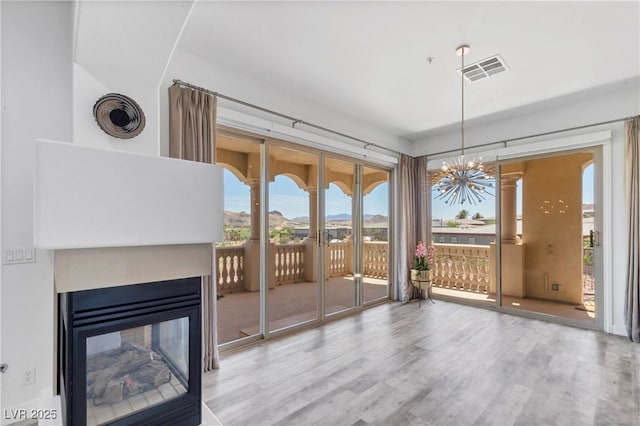 unfurnished living room with hardwood / wood-style flooring and a multi sided fireplace