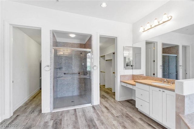 bathroom with vanity, hardwood / wood-style flooring, and walk in shower