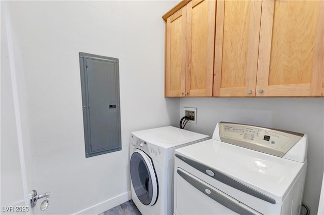 laundry room featuring cabinets, electric panel, and washer and clothes dryer