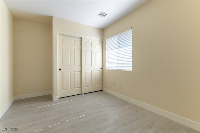 unfurnished bedroom with a closet and light hardwood / wood-style flooring