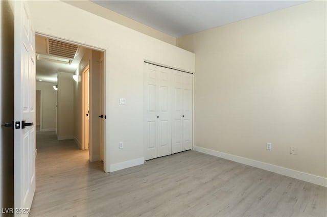 unfurnished bedroom with light hardwood / wood-style floors and a closet