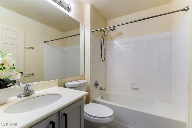 full bathroom featuring tiled shower / bath, vanity, and toilet