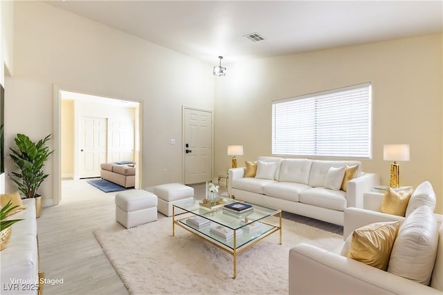 living room with light hardwood / wood-style flooring and a high ceiling