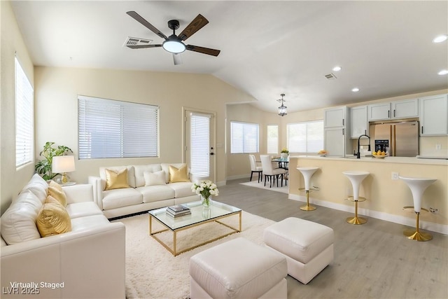 living room with vaulted ceiling, ceiling fan, sink, and light hardwood / wood-style floors