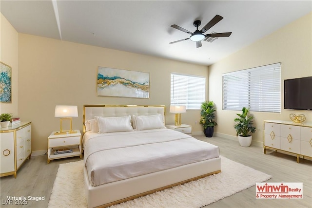 bedroom with ceiling fan, lofted ceiling, and light wood-type flooring