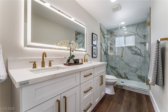 bathroom featuring hardwood / wood-style flooring, vanity, toilet, and walk in shower