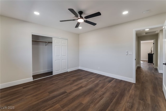 unfurnished bedroom with ceiling fan, dark hardwood / wood-style flooring, and a closet