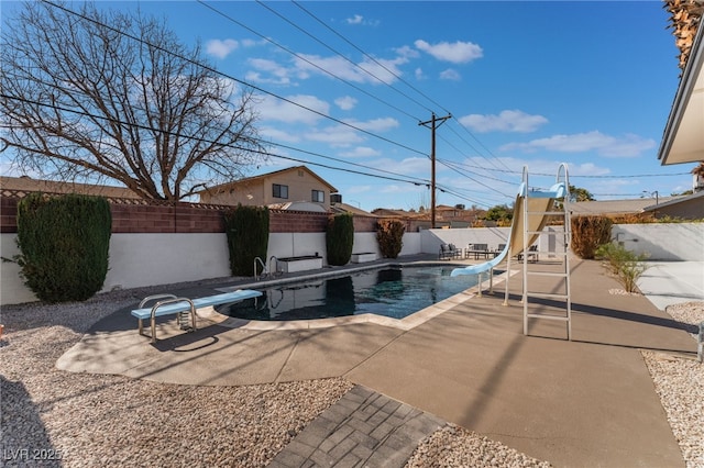 view of pool featuring a patio, a diving board, and a water slide